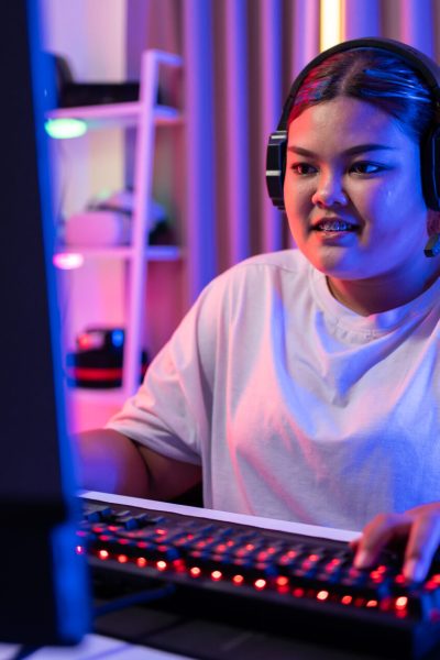 Asian beautiful Esport woman gamer play online video game on computer. Attractive young girl gaming player feel happy and enjoy technology broadcast live streaming while plays cyber tournament at home